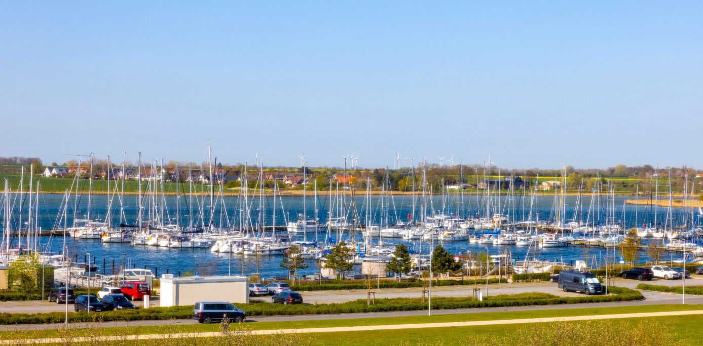Hafen mit zahlreichen Segelbooten und klarem Himmel im Hintergrund.
