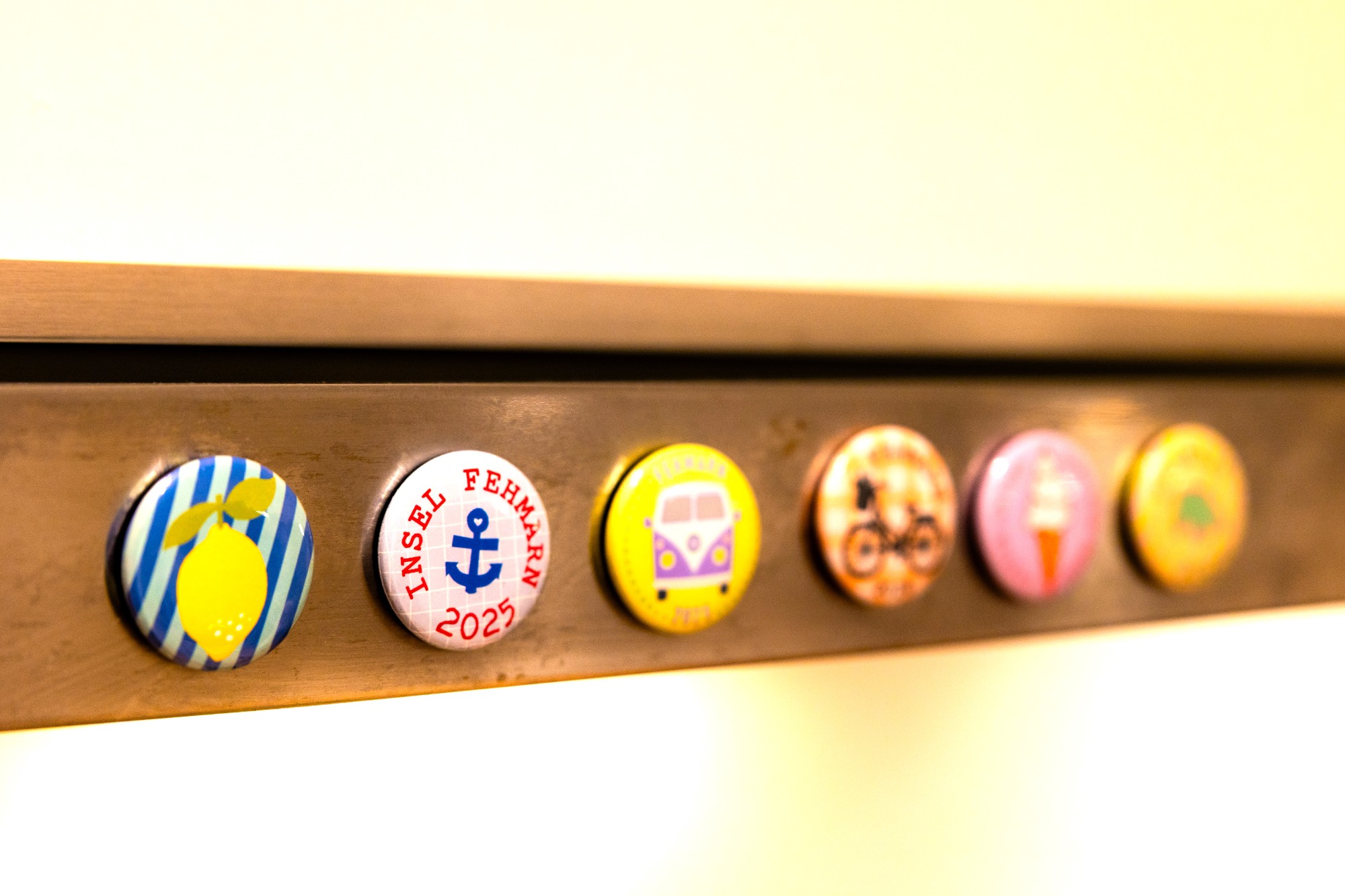 Fehmarn Buttons Bunte Buttons mit verschiedenen Motiven auf einer Metallleiste.