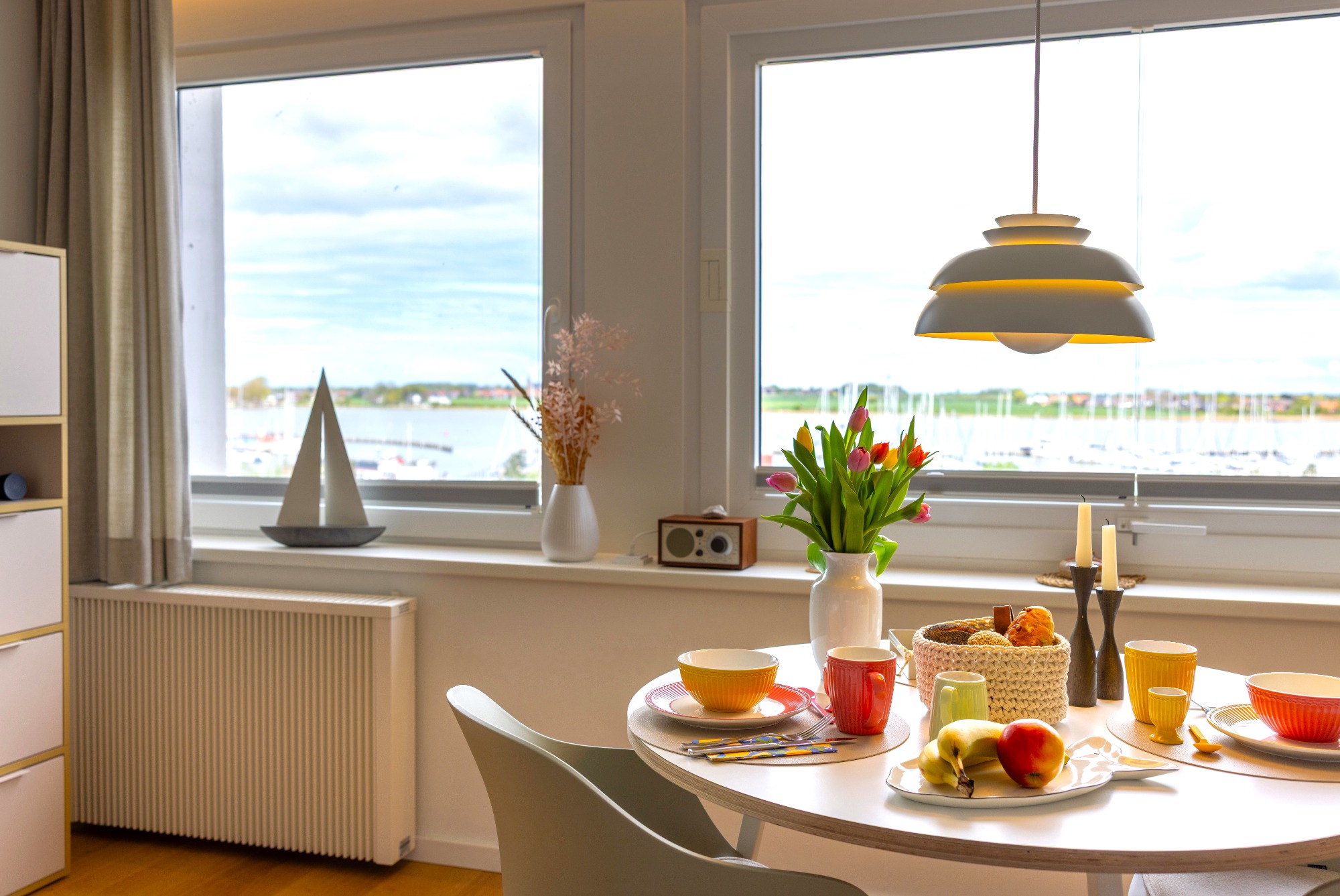 Essbereich: Bester Ausblick Helle Essbereich mit Tisch, Obstschale und Ausblick auf Wasser und Landschaft.