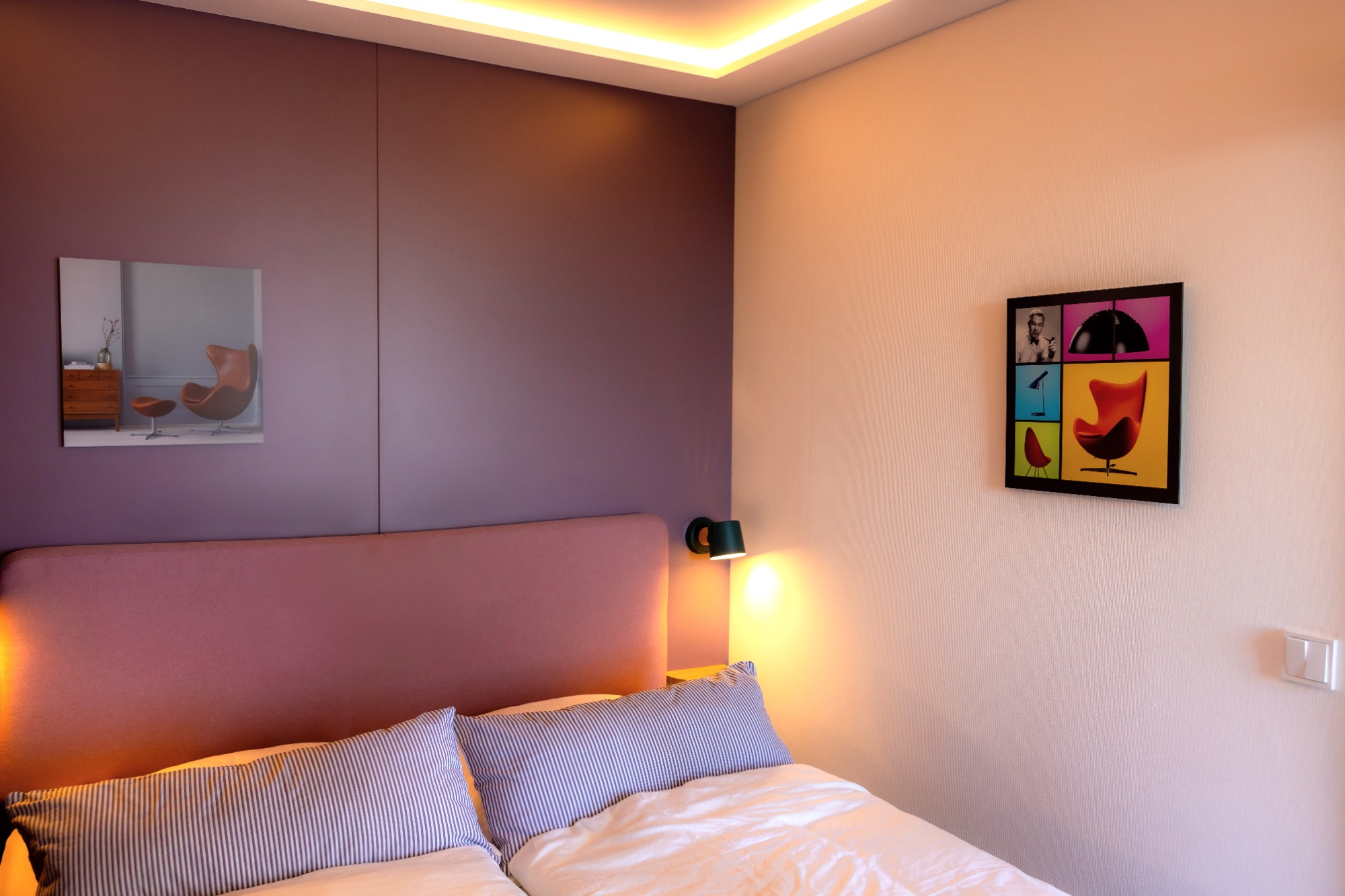 Komfort-Boxspringbett 160x200 Heller, moderner Schlafzimmer mit einem Bett, Bildern an der Wand und sanfter Beleuchtung.