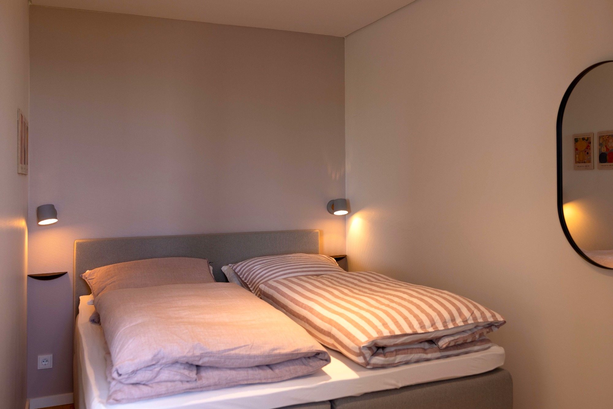 Komfort-Boxspringbett Gemütliches Schlafzimmer mit zwei Einzelbetten und modernem Spiegel.